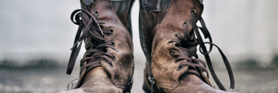 pair of brown leather boots in pavement